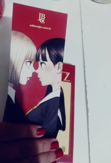 Duas personagens femininas próximas, com uniformes escolares e uma com marcas de mordida no pescoço.
(é o marcador de texto), cor de fundo, vermelho